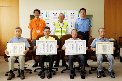 【写真】前列左から秋葉区交通安全協会古田支部代表本間さん、秋葉区交通安全協会小合支部代表今井さん、秋葉区交通安全協会石澤さん、佐々木さん、後列左から夏目区長、秋葉区交通安全協会鬼島会長、秋葉警察署齋藤交通課長