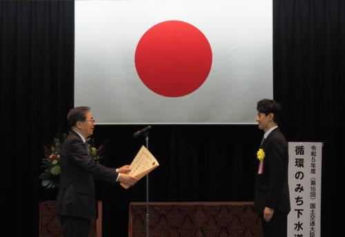 表彰の様子・国土交通大臣と学生