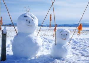 あたりめをつるした竿が手になっている雪だるまの写真